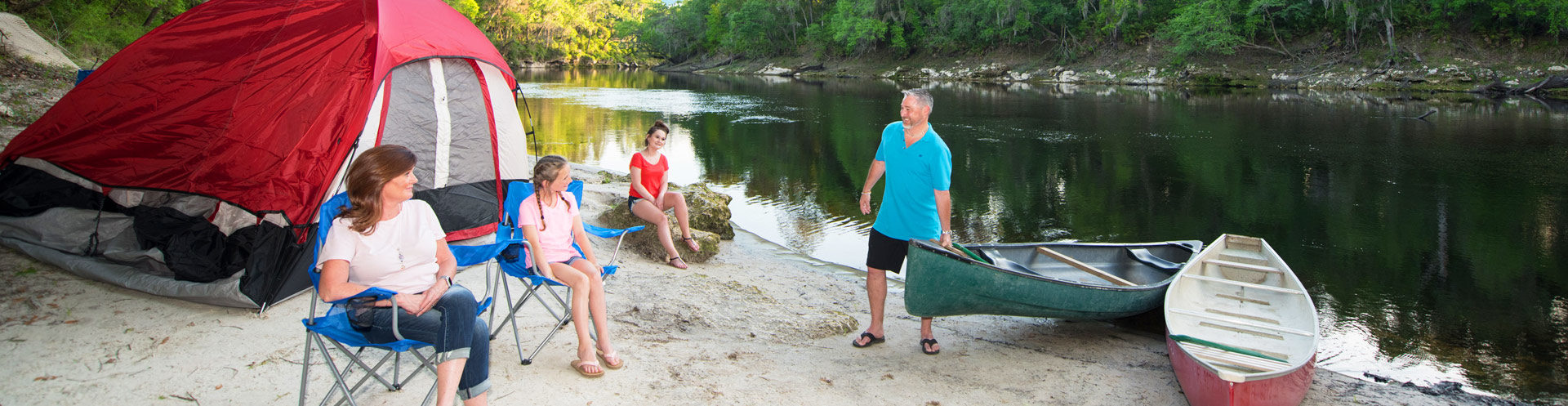 family at campground in suwannee with tent and kayaks