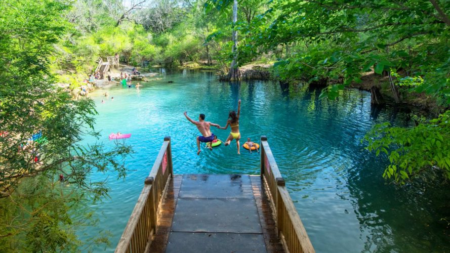 man and woman jumping into royal springs from dive platform