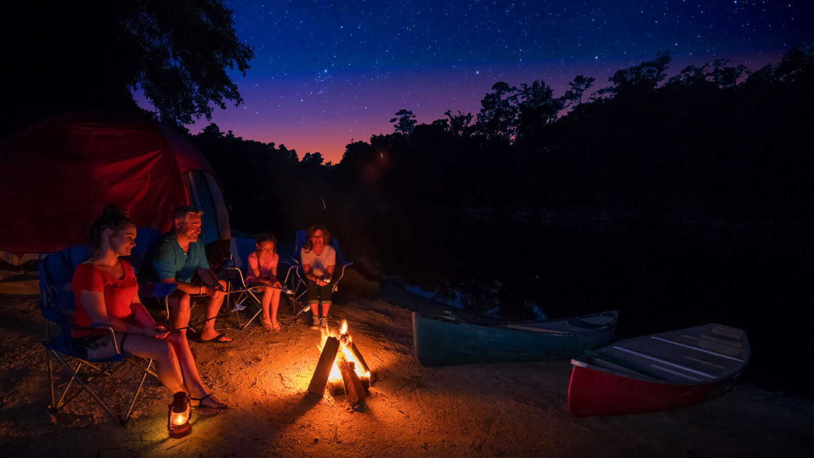 family roasting marshmallows at night in Suwannee campground
